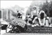  ?? JOHN J. KIM/CHICAGO TRIBUNE ?? Helmets sit on the sideline as Northern Illinois University Huskies football players have a walk-through at Huskie Stadium in 2019 in DeKalb.