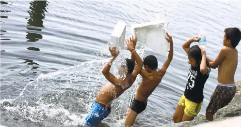  ?? PNA FOTO/ AVITO C. DALAN ?? CAREFREE. Children frolic in the dirty waters of Manila Bay, unmindful of the serious health risks. A new executive order seeks to help couples have only the number of children they can afford to raise.