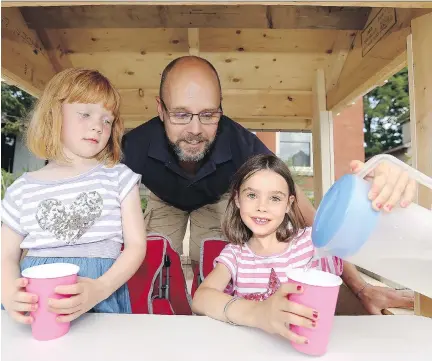  ?? JULIE OLIVER ?? Adela Andrews, left, and big sister Eliza had their lemonade stand shut down by the National Capital Commission on Sunday because they had no permit. The NCC apologized on Monday, and will speed up the issuing of a permit to the two girls, shown with their father Kurtis Andrews.