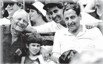  ?? COURTESY ?? Andrew Ratner, back row, in the cap, at a 1994 baseball game at Camden Yards with his grandfathe­r George Ratner, left; father Seymour Ratner, right; and son Alexander.