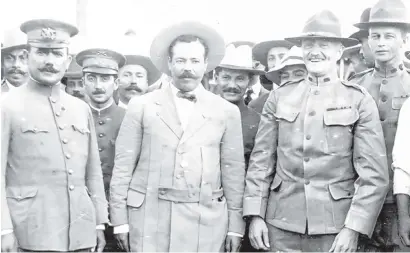  ??  ?? In this photo taken before the 1916 raid, Pancho Villa, center, stands next to U.S. Gen. John Pershing, right. Pershing would lead the hunt for Villa after the raid.