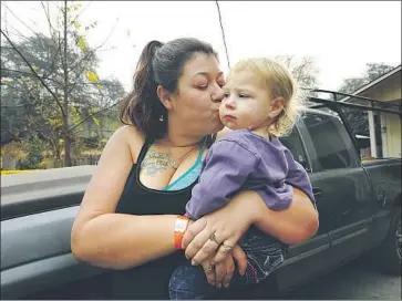  ?? Carolyn Cole Los Angeles Times ?? MEGAN BUTLER, with daughter Aurora, said she and others who lost homes in Concow, Calif., feel ignored: “Maybe because we’re so close to Paradise that they consider it all the same. But it’s Concow. It’s my home.”