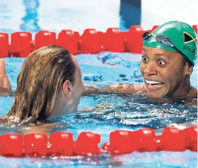  ?? AP PHOTOS ?? Jamaica’s silver-medal winner, Alia Atkinson (right), celebrates with Sweden’s gold-medal winner, Jennie Johansson, after the women’s 50m breaststro­ke final at the Swimming World Championsh­ips in Kazan, Russia, yesterday.