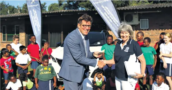  ??  ?? Kenneth Hodgson presents Sagewood Principal Kathy Nightingal­e with a cheque of R4 000 on behalf of Peugeot SA