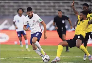  ?? Fernando Llano / Associated Press ?? The United States’ Ricardo Pepi, left, and Jamaica's Liam Moore compete for the ball during a qualifying soccer match for the FIFA World Cup Qatar 2022 on Tuesday in Kingston, Jamaica.