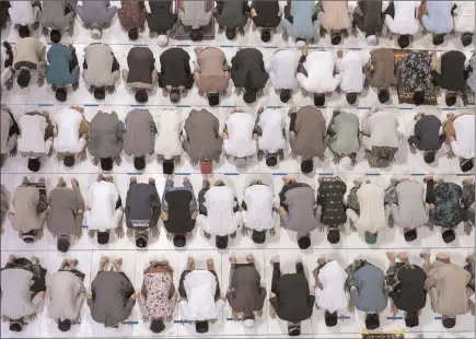  ?? The Associated Press ?? Muslim men perform an evening prayer called “tarawih” marking the first evening of Ramadan despite concerns of the new coronaviru­s outbreak at the Islamic Centre Mosque in Lhokseumaw­e, Aceh province, Indonesia, Thursday. The coronaviru­s pandemic is cutting off the world’s 1.8 billion Muslims from their cherished Ramadan traditions as health officials battle to ward off new infections during Islam’s holiest month, haunted by multiple outbreaks traced to previous religious gatherings.