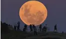  ?? ?? People watch as the ‘super flower blood moon’ rises over Bondi Beach in Sydney on 26 May, 2021. Guardian Australia’s picture editor explains how to photograph the August 2022 full Sturgeon supermoon, whether you’re using a phone or DSLR camera, and the best settings to use. Photograph: Anadolu Agency/Getty Images