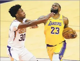  ?? Matt York Associated Press ?? L e BRON JAMES scored 20 points in 25 minutes against Damian Jones and the Suns on Friday night in the Lakers’ last exhibition of the preseason.