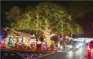  ?? Robin Jerstad/Contributo­r ?? Motorists pass the home of John and Brenda Wilson, featuring over 100,000 lights, during the 2020 Windcrest Light Up. This year’s event honors the 200th anniversar­y of Clement Clark Moore’s poem.