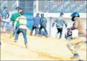  ?? HTPHOTO ?? ▪ A policeman driving away a mob in Aligarh on Friday.