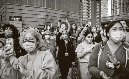  ??  ?? Medical personnel attend a daily applause in their honor on April 28 outside the NYU Langone Medical Center in Manhattan. Workers’ comp is not guaranteed to essential workers who get COVID-19 while on the job in most states.