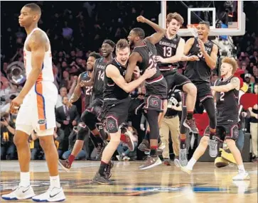  ?? Maddie Meyer Getty Images ?? SOUTH CAROLINA players whoop it up on the court after defeating Florida in the East Regional final. Until this year’s tournament the Gamecocks hadn’t won an NCAA tournament game since 1973.