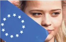  ?? SERGEY DOLZHENKO, EUROPEAN PRESSPHOTO AGENCY ?? A Ukrainian student holds a flag with the EU emblem.