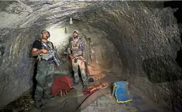  ??  ?? Armed inspection:
Members of the Afghan Special Forces investigat­ing a cave used by suspected militants at the site where a MOAB (mother of all bombs) struck in Achin, Nangarhar, recently. — Reuters