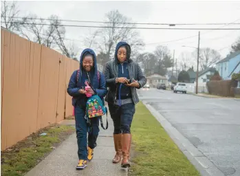  ?? KIRSTEN LUCE/THE NEW YORK TIMES ?? J. Marie Jones walks her daughter, Kaiya, to school Jan. 31 in Roosevelt, New York.