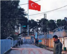  ?? Agence France-presse ?? Agencies A member of the Kurdish Internal Security Police Force of Asayish stands guard in Darbasiyah on Thursday as the Turkish flag flutters on the opposite side of the border crossing with Turkey.