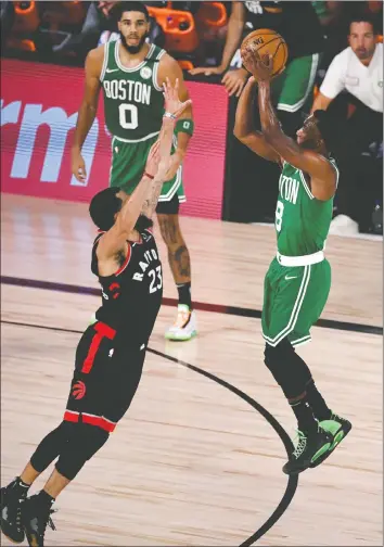  ?? GETTY IMAGES ?? The Celtics’ Kemba Walker shoots a three-pointer over leaping Raptor Fred VanVleet during Thursday’s game in Orlando. Walker had 29 points in Game 3.