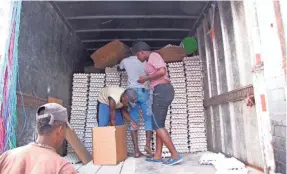  ??  ?? Employees of a Dominican egg company unload a truck in Jimani, Dominican Republic, before the eggs are shipped across the border to Haiti. Jimani is the site of a major twice-weekly market, where Haitians come to buy many everyday items. Smugglers also...