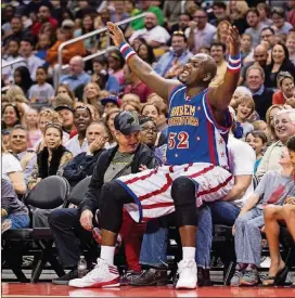  ?? CONTRIBUTE­D BY HARLEM GLOBETROTT­ERS ?? Harlem Globetrott­er big man Big Easy Lofton, all 6-foot-9 and 250 pounds of him, playfully takes a courtside seat, ignoring the fan already sitting there.