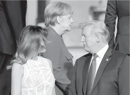  ?? PABLO MARTINEZ MONSIVAIS, THE ASSOCIATED PRESS ?? German Chancellor Angela Merkel walks behind U.S. President Donald Trump and his wife, Melania Trump, on Wednesday after gathering at the Parc du Cinquanten­aire in Brussels, Belgium, for a group photo.