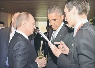  ?? — Gambar Reuters ?? DINGIN: Obama mendengar apa yang diperkatak­an Putin (dua kiri) melalui penterjema­hnya semasa menghadiri sidang kemuncak APEC di Beijing, semalam.