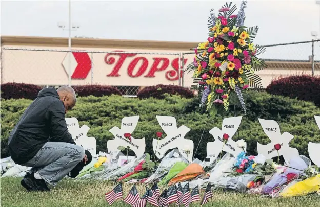  ?? ?? Un hombre reza en el memorial levantado por las víctimas del atentado supremacis­ta en un supermerca­do de la ciudad de Buffalo (Nueva York)