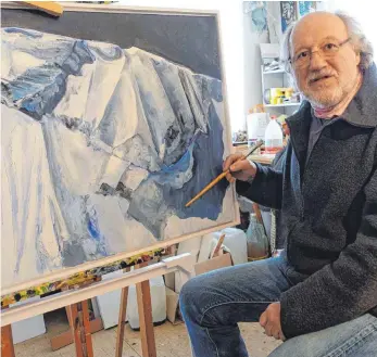  ?? FOTO: MARCUS GOLLING ?? Manfred Bittner liebt die Berge – und er malt sie derzeit auch gerne: Hier arbeitet er in seinem Atelier, gleich über der Insel-Galerie, an einem Bild.