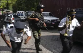  ?? RAMON ESPINOSA — THE ASSOCIATED PRESS ?? Police escort musicians arriving for the swearing-in ceremony of a transition­al council tasked with selecting a new prime minister and cabinet at the Prime Minister's office in Port-au-Prince, Haiti, Thursday.