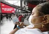  ??  ?? Francis Thornton waits for her name and number to be called to receive her first vaccinatio­n Wednesday at Mercedesbe­nz Stadium in Atlanta.