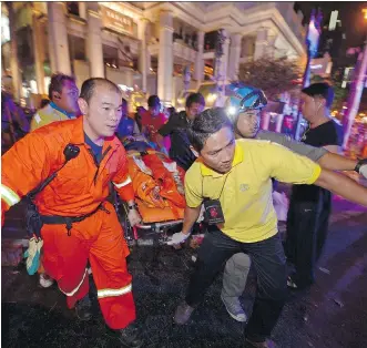  ?? PORNCHAI KITTIWONGS­AKUL/ GETTY IMAGES ?? Rescue workers carry an injured person after a bomb exploded at a religious shrine in central Bangkok at rush hour on Monday.