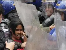  ?? AARON FAVILA — THE ASSOCIATED PRESS ?? Police push an activist as she tries to march near the presidenti­al palace during an Internatio­nal Women's Day protest in Manila on Friday.