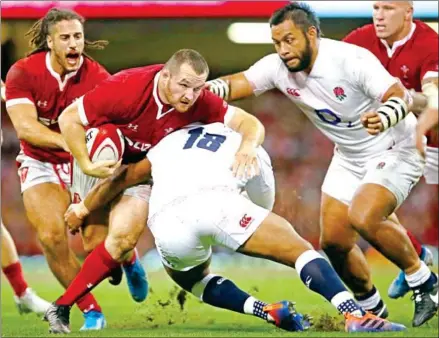  ?? GEOFF CADDICK/AFP ?? Wales hooker Ken Owens (second left) is tackled by England prop Kyle Sinckler (centre) during the internatio­nal rugby union Test match between Wales and England at Principali­ty Stadium in Cardiff, south Wales, on Saturday.