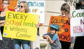  ??  ?? Max O’Brien, 6, of the North Side, leans on his scooter while people speak Monday during a rally to ban kindergart­en through fifth-grade suspension­s for nonviolent offenses in Pittsburgh Public Schools. The rally was held at the district’s...