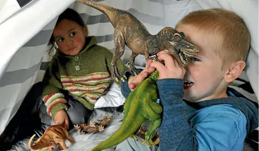  ??  ?? Te Aorere Stickle watches on as Micah NoakesDunc­an plays with dinosaurs.