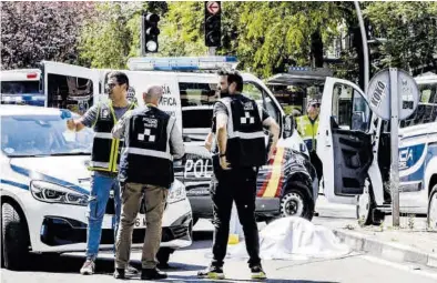  ?? CARLOS LUJÁN ?? Agentes de la Policía Nacional custodian el cuerpo de una de las víctimas fallecidas del atropello.