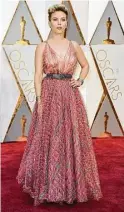  ?? Jordan Strauss / Associated Press ?? Harris’ Calvin Klein column dress and Scarlett gown get mixed reviews.