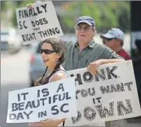  ?? AP PHOTO ?? Leslie Minerd, of Columbia, S.C., holds a sign as she celebrates outside the South Carolina Statehouse, Thursday after the State voted to remove the controvers­ial Confederat­e flag from outside the Statehouse.