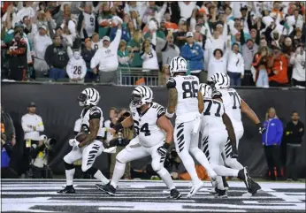  ?? JEFF DEAN — THE ASSOCIATED PRESS ?? Bengals running back Joe Mixon, left, celebrates after his rushing touchdown against the Miami Dolphins during the first half of Thursday night’s game in Cincinnati.