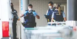  ?? FIONA GOODALL / GETTY IMAGES ?? Officers stand guard in front of an Auckland, N.z.-area mall on Friday where
an ISIL supporter stabbed six people before being shot dead by police.