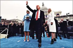  ?? Jim Bourg / Pool / Getty Images ?? President Donald Trump waves after taking the oath of office as the 45th president of the United States on Jan. 20, 2017.