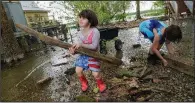  ?? AP/MATTHEW HINTON ?? Delilah Campbell, 4, (left) and her sister Tallulah Campbell, 8, clear out driftwood and other debris Thursday near New Orleans as Tropical Storm Barry approaches.