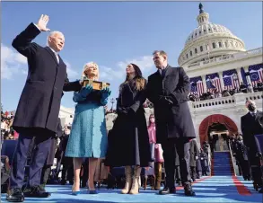  ?? Andrew Harnik / Associated Press ?? Joe Biden is sworn in as the 46th president of the United States by Chief Justice John Roberts as Jill Biden holds the Bible during the 59th Presidenti­al Inaugurati­on at the U. S. Capitol in Washington on Jan. 20, as their children Ashley and Hunter watch.