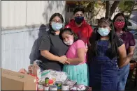  ??  ?? From left, Abigail Leocadio, stands with her children, Areli, 9, Eliel, 12, Zeret, 10, and Samai, 15, after a delivery from the Emmaus House food pantry in November in Phoenix. Leocadio says the food provides less than half of what her family eats in four weeks, but significan­tly reduces their monthly bill. Before the pandemic, the family was saving to buy a house, but that money has been wiped out.
(AP/Ross D. Franklin)