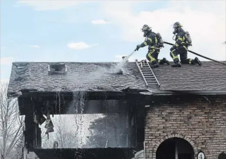  ?? DAVE JOHNSON
THE WELLAND TRIBUNE ?? Welland Fire and Emergency Services firefighte­rs spray water on the roof of 4 Barrington Dr. on Tuesday.