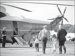  ?? The New York Times/AL DRAGO ?? President Donald Trump, with an aide and his grandchild­ren, Arabella and Joseph Kushner, walks toward Marine One at the airport in Morristown, N.J., to begin his summer vacation at his golf club in Bedminster, N.J.