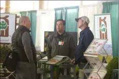  ??  ?? Exhibitors for Keithly-Williams Seeds answer questions from one of the farmers in attendance at the summit about their products. EDWIN DELGADO PHOTO.