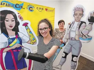  ?? CLIFFORD SKARSTEDT EXAMINER ?? Rachel Quilty, left, and Breanna Mackenzie of the Council for Persons with Disabiliti­es set up props at the Venture North building on Thursday in downtown Peterborou­gh for Capable Con.