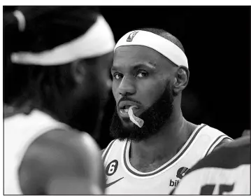  ?? ASHLEY LANDIS / ASSOCIATED PRESS ?? Los Angeles Lakers forward Lebron James looks toward the camera as guard Patrick Beverley walks by Tuesday during a loss to the Oklahoma City Thunder in Los Angeles.