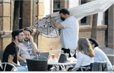  ?? J. C. MUÑOZ ?? Un grupo de personas se reúnen en un bar de Sevilla.