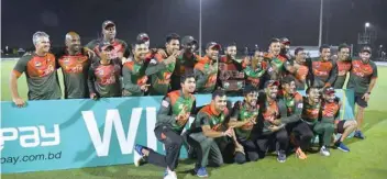  ?? — AFP ?? Bangladesh’s players pose with the trophy after winning the third and final T20I match against West Indies.